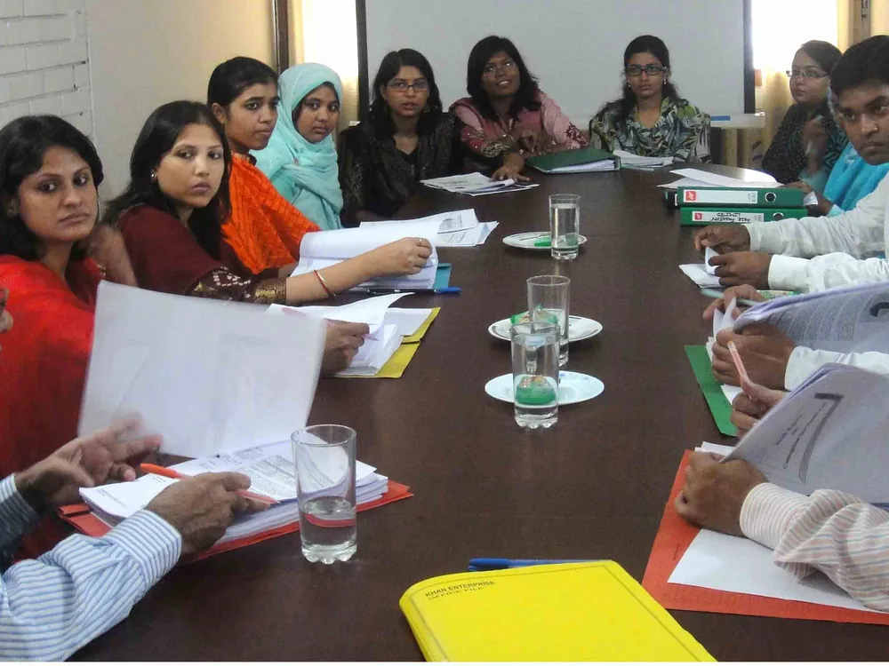 An NCR rating committee meeting in progress, with external experts reviewing rating papers around the table